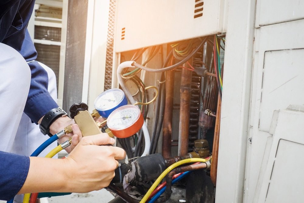 Certified technician diagnosing a residential central air conditioning unit