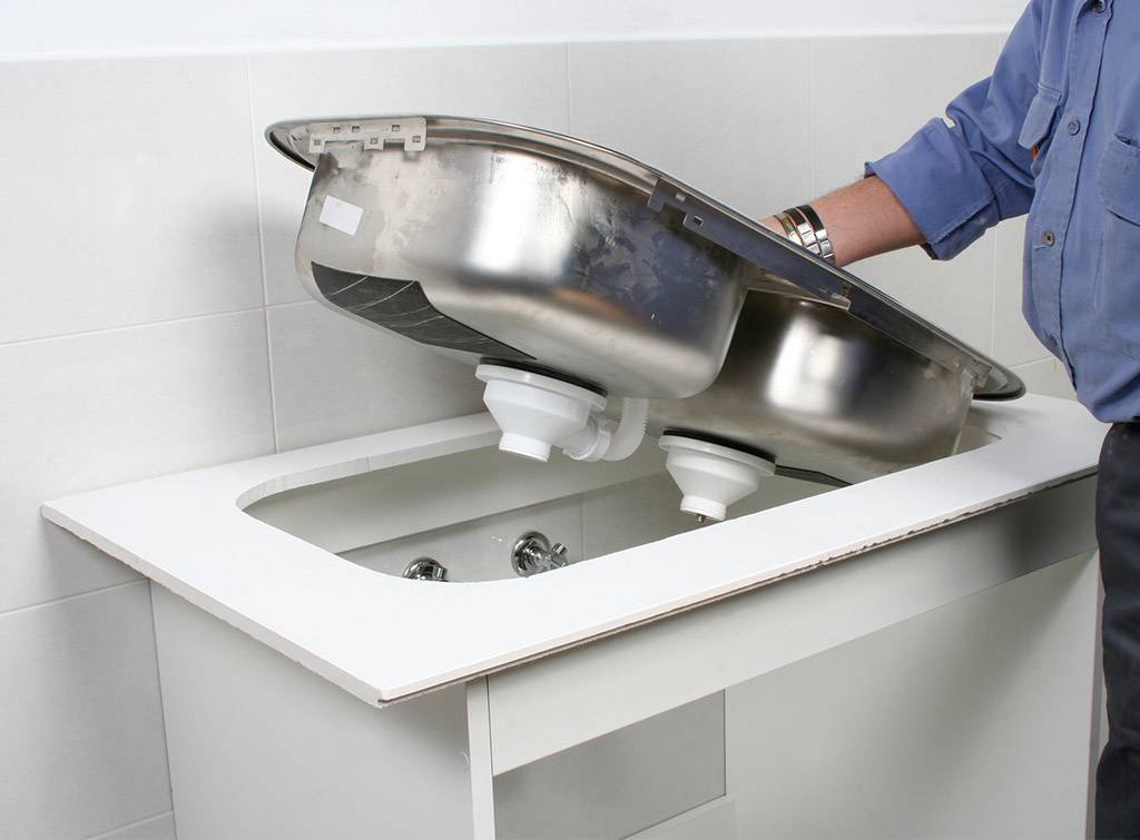 Licensed plumbing technician installing a premium new kitchen sink basin