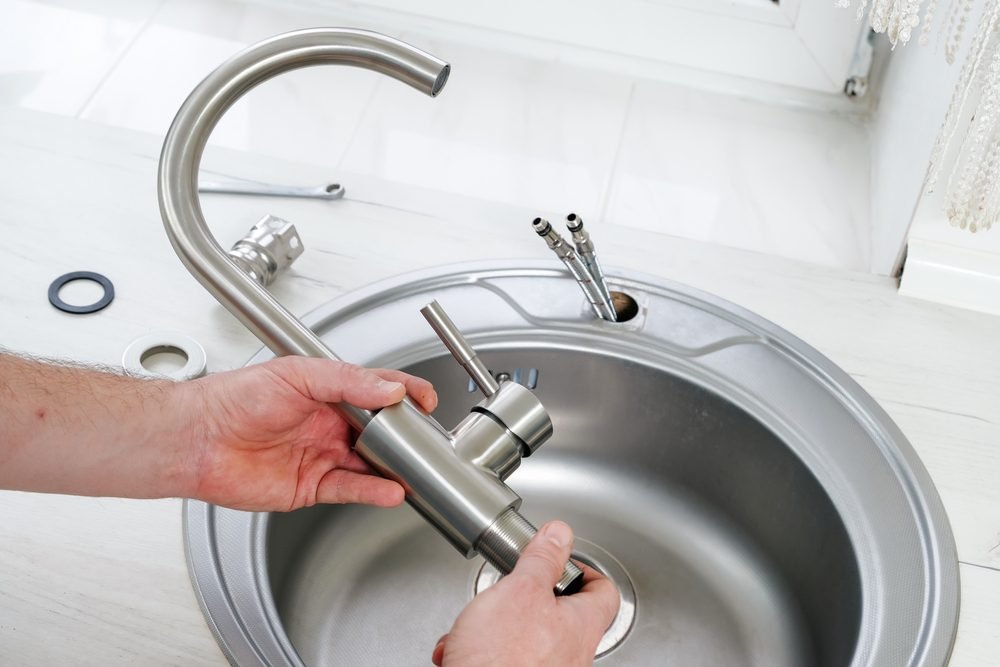 Licensed plumber installing a modern luxury shower valve fixture assembly